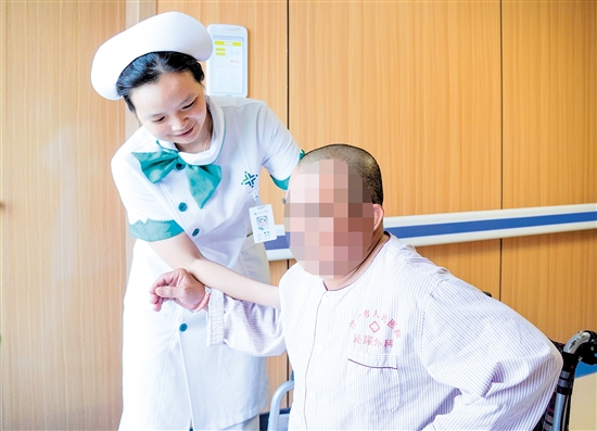 護(hù)士攙扶雙下肢無(wú)力患者上病床。