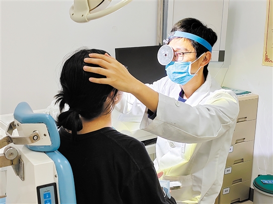 醫(yī)生為患者檢查鼻子。