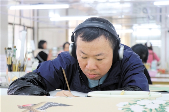 畫師戴著耳機(jī)，可以讓精神更專注。（受訪者供圖）