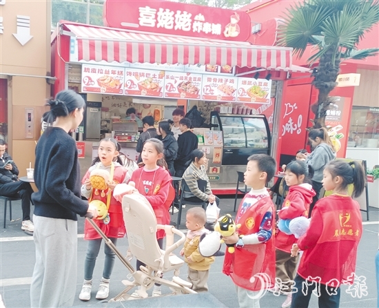 統(tǒng)一身著志愿者服裝的孩子們化身“愛心小掌柜”，向顧客推銷商品。