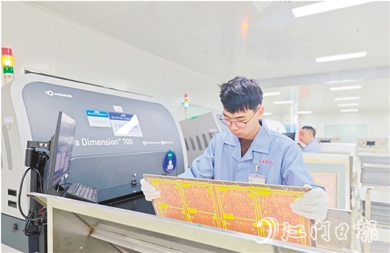 在鶴山中富生產(chǎn)車間，員工操作自動(dòng)化設(shè)備趕制電路板。