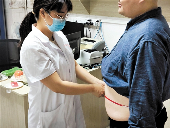 醫(yī)生為記者測(cè)量腰圍。