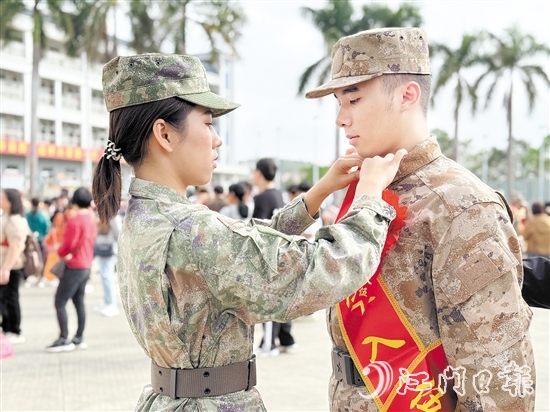 在歡送儀式現(xiàn)場，老兵姐姐為新兵弟弟整理軍裝。