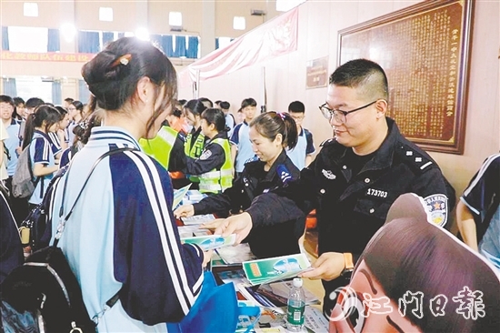 民警向?qū)W生發(fā)放安全知識宣傳資料。