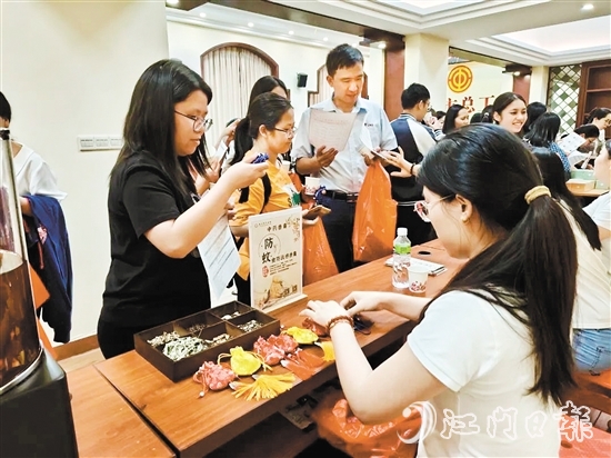 職工們與醫(yī)生探討中藥的成分和比例，制作防感驅(qū)蚊中藥香囊。