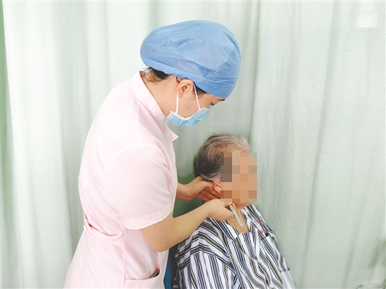 醫(yī)護人員為患者進行中醫(yī)外治療法。