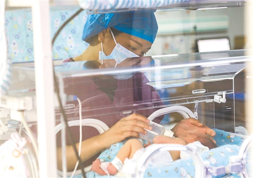這是一雙小心翼翼的手。在江門市婦幼保健院新生兒科，護(hù)士李麗婷化身臨時“奶媽”，手持奶瓶給早產(chǎn)兒喂奶。她時而調(diào)整奶瓶角度，時而放緩速度，用耐心與愛心為小生命構(gòu)筑溫暖港灣，陪伴他們跨越成長路上最初的難關(guān)。