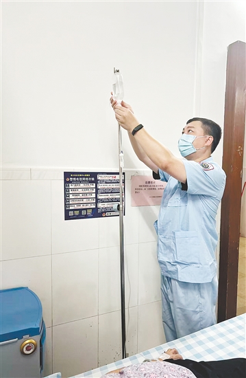 吳益浩核對藥液、為患者調整輸液流速。