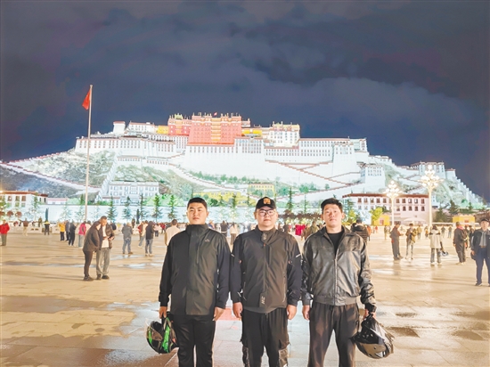 余鴻威（左一）與摩友在拉薩布達(dá)拉宮前合影留念。