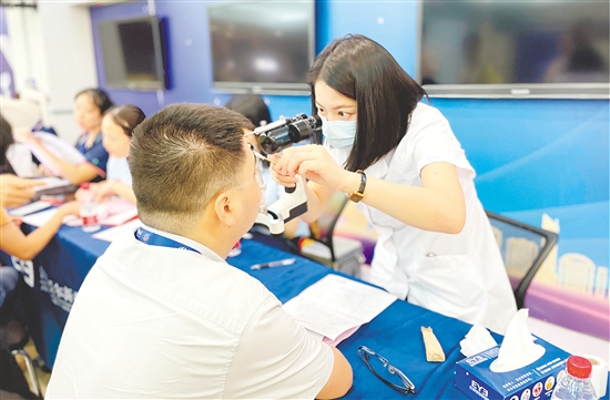 醫(yī)護(hù)人員為企業(yè)職工檢查眼睛。