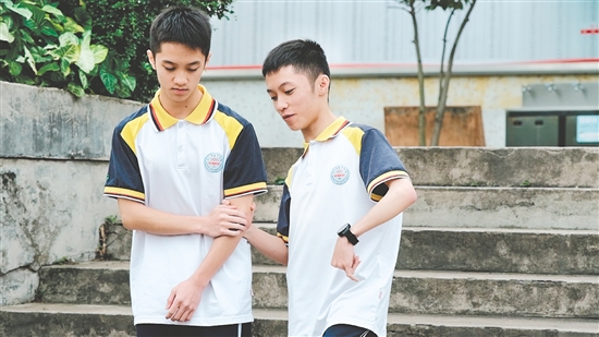 校園里，弟弟（左）和哥哥（右）相互扶持。