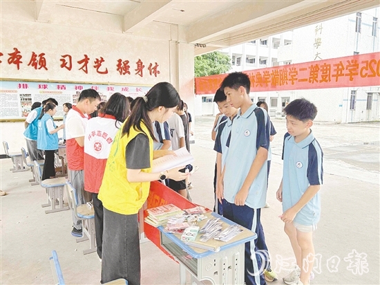 工作人員向?qū)W生宣傳防溺水知識。