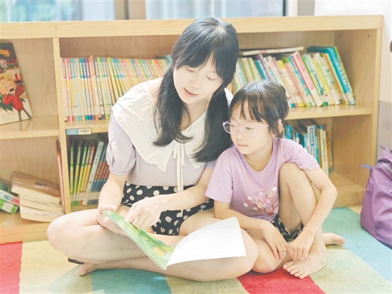 在龍溪湖閱讀中心，一位家長正陪伴孩子讀繪本。