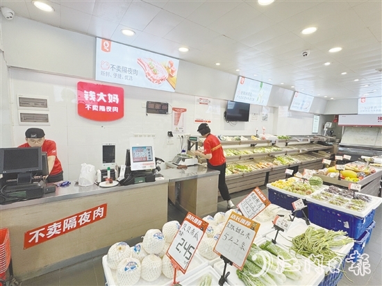 錢大媽生鮮店的工作人員正在線上接單并準(zhǔn)備菜品。