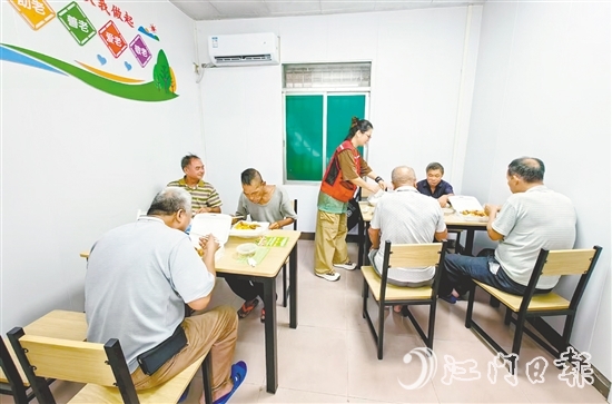 老人在助餐點(diǎn)享用熱氣騰騰的飯菜。