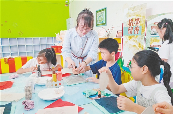 在導(dǎo)師的指導(dǎo)下，孩子們紛紛拿起紙張，在拓板上謹(jǐn)慎操作。