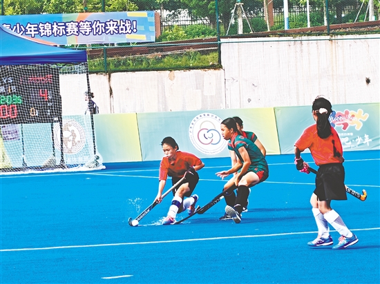 共和鎮(zhèn)中心小學(xué)女子曲棍球隊(duì)隊(duì)員（紅色隊(duì)服）在比賽中頑強(qiáng)拼搏。