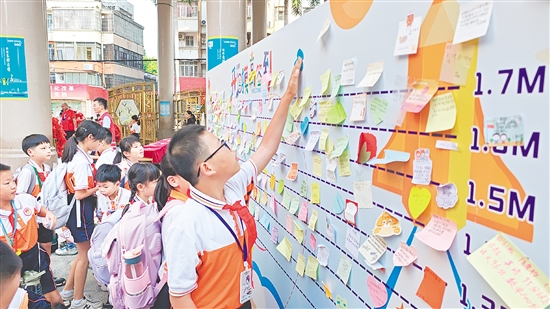 沙坪街道第一小學(xué)設(shè)立“開學(xué)摸高簽到墻”，學(xué)生貼上寫有新學(xué)期愿望的“心愿卡”。
