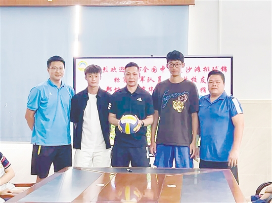 鄭銘毅（左二）與譚華鋒（右二）將親筆簽名的排球贈予母校。
