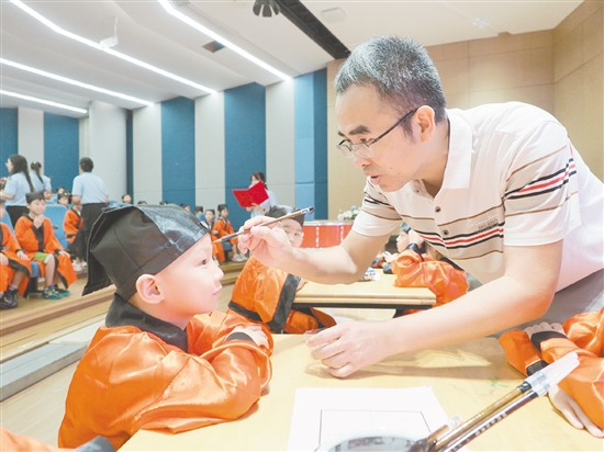 在朱砂啟智環(huán)節(jié)，教師用毛筆在新生的額頭點(diǎn)上紅痣。