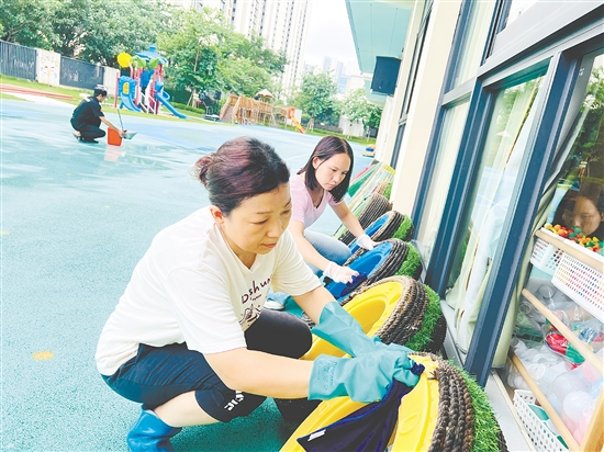 蓬江區(qū)實驗幼兒園的老師們把教學道具輪胎放在避雨處，并清理積水。