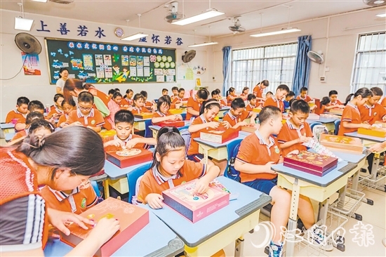 學生充分發(fā)揮創(chuàng)意，將廢舊月餅盒變廢為寶，制作成時鐘表盤、冰箱貼等。