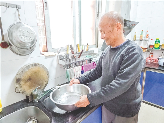 榕樹村村民麥成建在廚房用干凈的自來水清洗餐具。