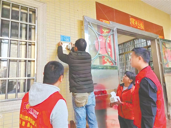 服務(wù)站工作人員細(xì)心地將“光榮之家”牌匾安裝到位。