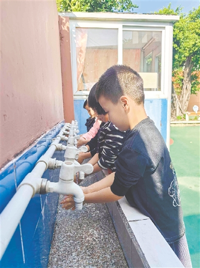 崖門鎮(zhèn)田邊村幼兒園的孩子們打開洗手池新安裝的節(jié)水型水龍頭，感受那潺潺流出的清澈好水。