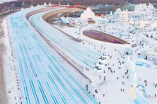 圖為當(dāng)日，游客在哈爾濱冰雪大世界園區(qū)體驗(yàn)“超級(jí)冰滑梯”（無人機(jī)照片）。新華社發(fā)