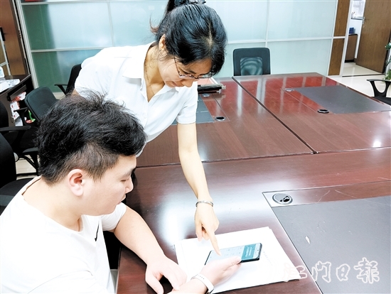 工作人員在指導(dǎo)市民線上交存住宅專項維修資金。陸沿任