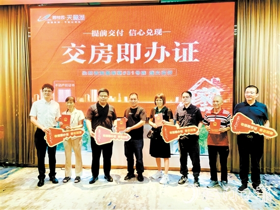 業(yè)主喜拿房產(chǎn)證和鑰匙。