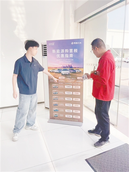 銷售人員向市民介紹優(yōu)惠政策。